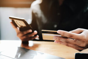 close up of someone using phone to make purchase with credit card