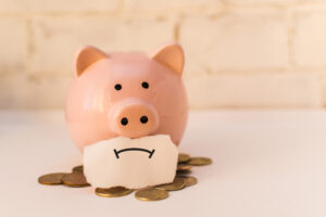 piggy bank with a drawn-on frown
